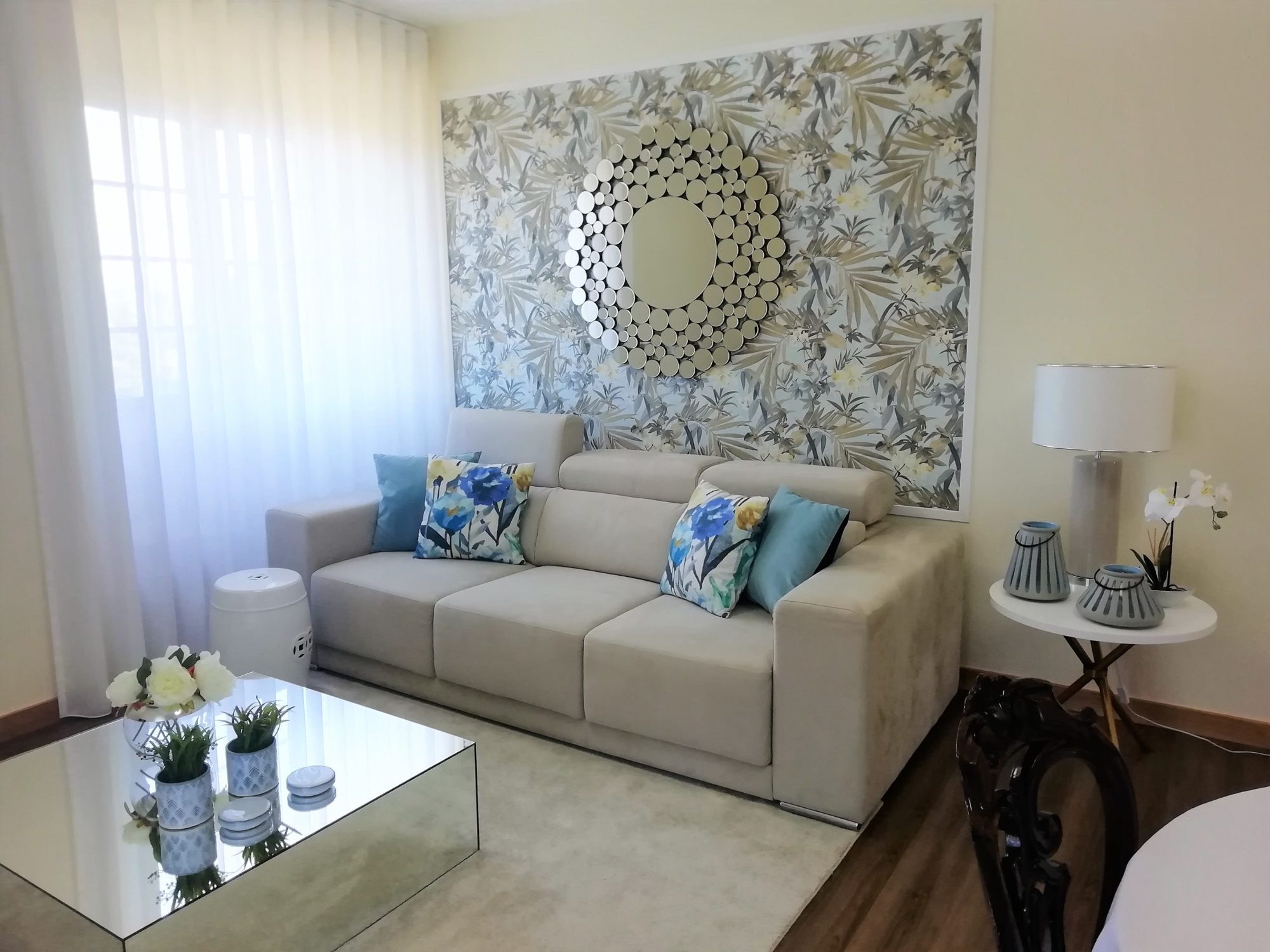 Sala de estar decorada pela Palma Interiores, com papel de parede decorativo e sofá claro