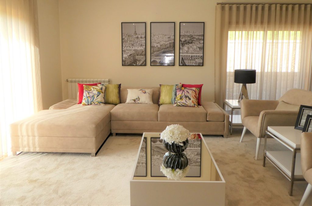 Sala de estar decorada pela Palma Interiores, com sofá de canto e cortinas de onda